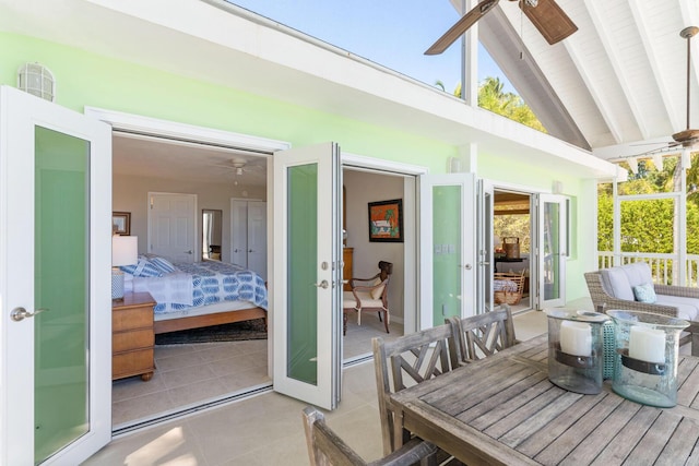 sunroom with lofted ceiling with beams, ceiling fan, and french doors