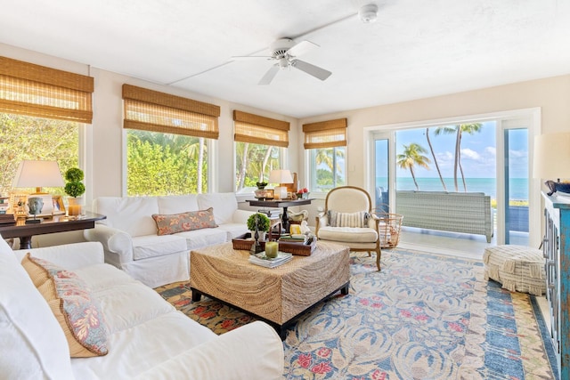 sunroom featuring a water view and ceiling fan