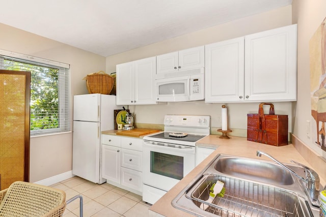 kitchen with white cabinetry, sink, white appliances, and light tile patterned floors