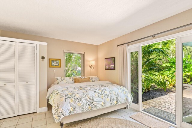 bedroom with light tile patterned floors, access to outside, and a closet