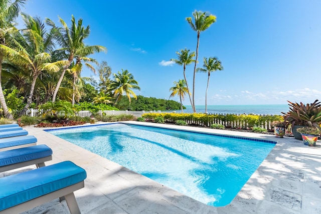 view of swimming pool featuring a patio area and a water view