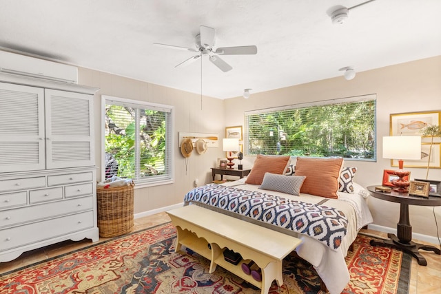 bedroom featuring a wall mounted AC and ceiling fan