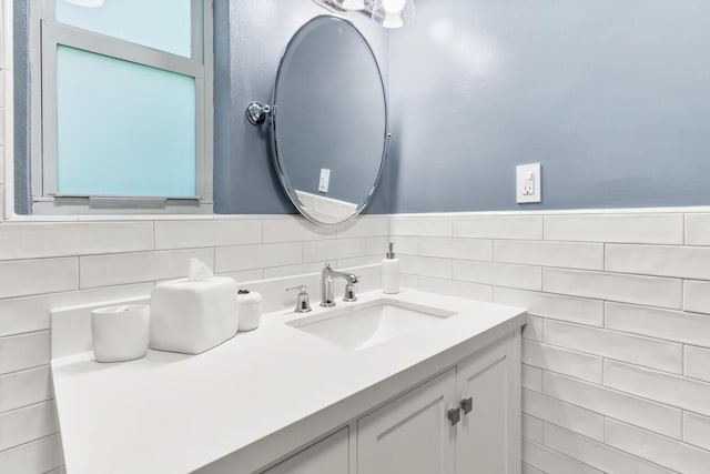 bathroom featuring vanity and tile walls