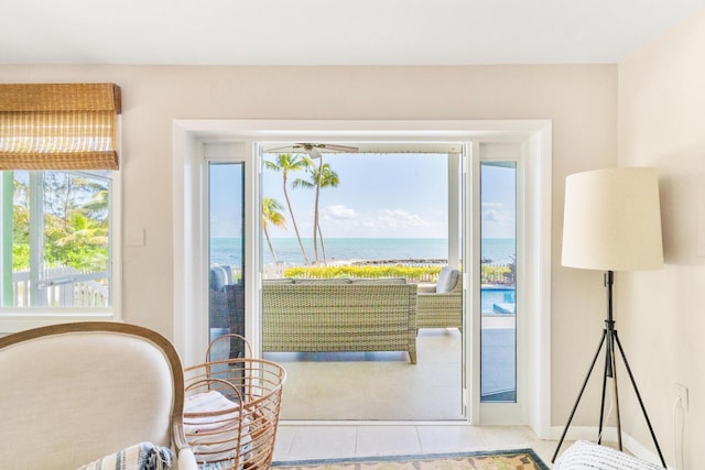 doorway to outside with a water view and light tile patterned floors