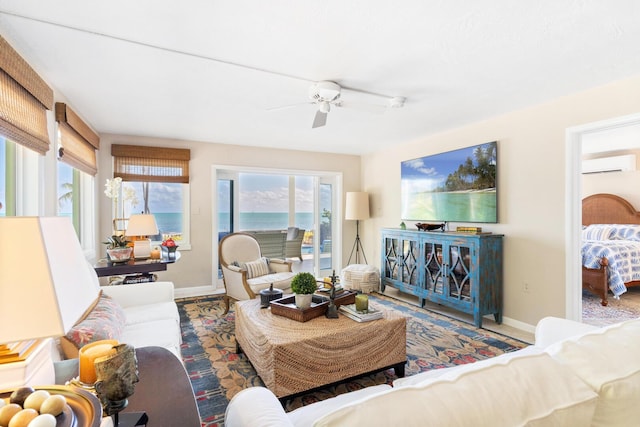 living room featuring ceiling fan, wood-type flooring, and a wall unit AC