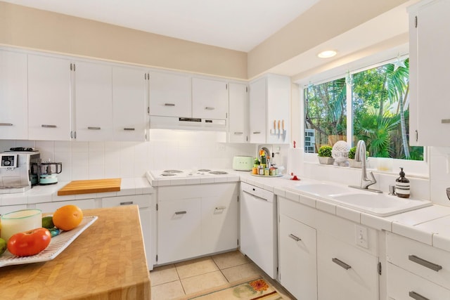 kitchen with white dishwasher, sink, white cabinetry, and tile countertops