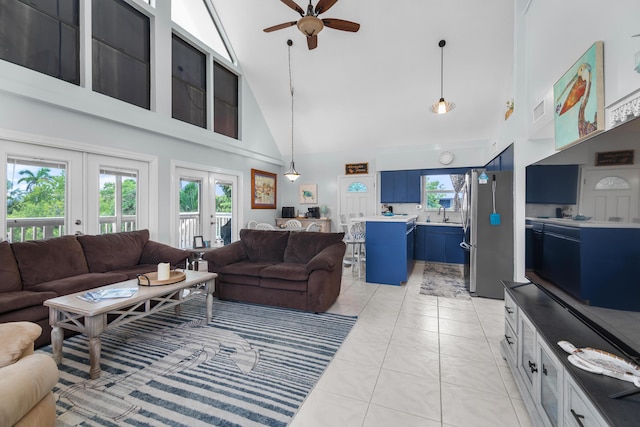 tiled living room featuring ceiling fan, sink, high vaulted ceiling, and french doors