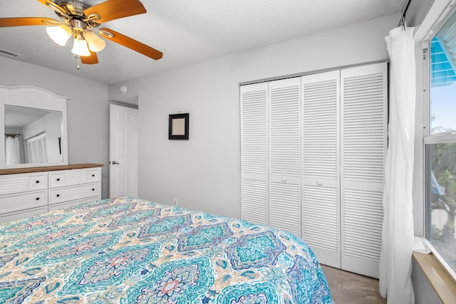 bedroom with ceiling fan, a closet, and a textured ceiling