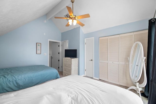 bedroom featuring vaulted ceiling with beams, ceiling fan, and a closet