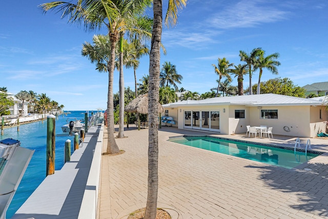 view of swimming pool featuring a patio area, french doors, and a water view