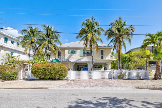 view of front of property with metal roof, a fenced front yard, driveway, and a gate