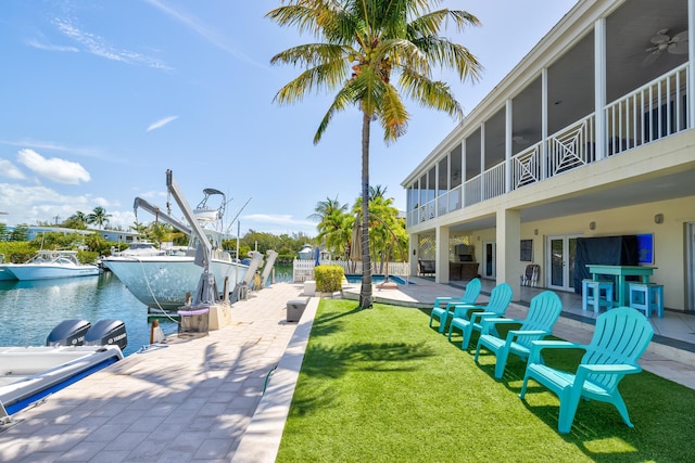 surrounding community featuring a patio area, a yard, a swimming pool, a boat dock, and a water view