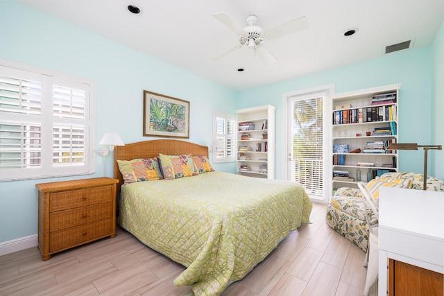bedroom with wood finished floors, visible vents, baseboards, and ceiling fan