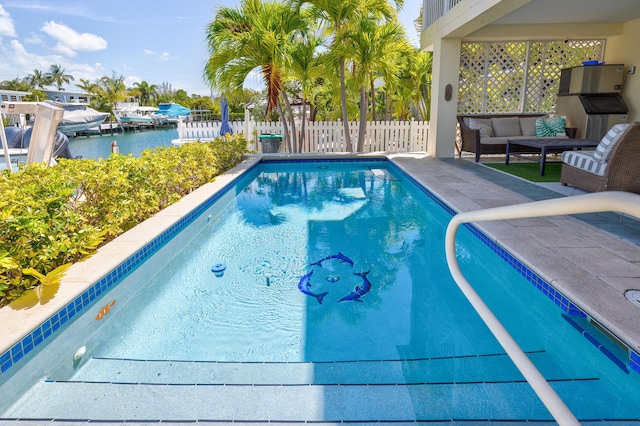 pool featuring an outdoor living space, a patio area, a water view, and fence