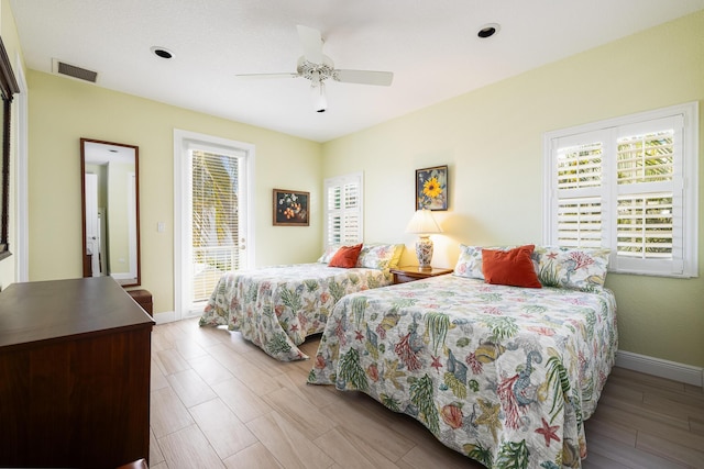 bedroom featuring baseboards, multiple windows, visible vents, and access to exterior