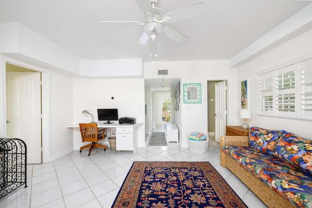 living room featuring light tile patterned floors, visible vents, baseboards, and ceiling fan