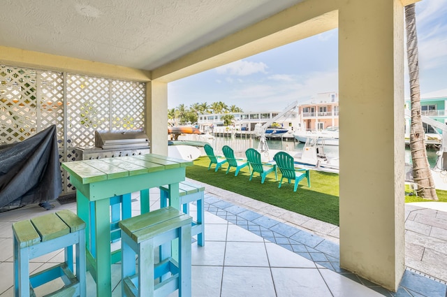 view of patio / terrace with a water view, a boat dock, and grilling area