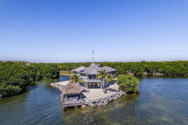 dock area featuring a water view, a wooded view, and boat lift