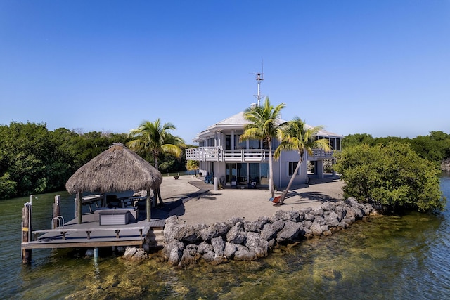 dock area featuring a gazebo, a water view, a patio area, and a balcony