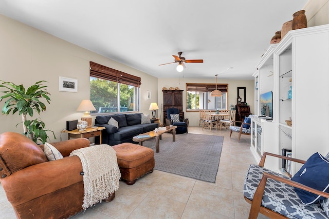 living room with light tile patterned floors, healthy amount of natural light, and a ceiling fan