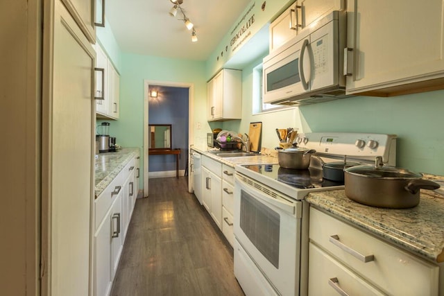 kitchen featuring white cabinetry, sink, light stone counters, dark wood-type flooring, and white appliances