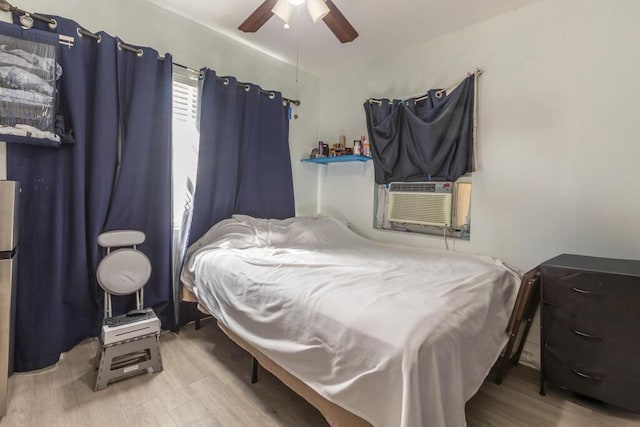 bedroom featuring cooling unit, ceiling fan, and light wood-type flooring