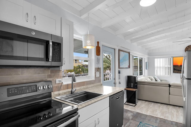 kitchen featuring tasteful backsplash, sink, vaulted ceiling with beams, white cabinets, and black appliances