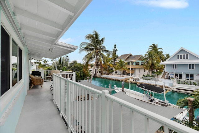 balcony with a water view and a dock