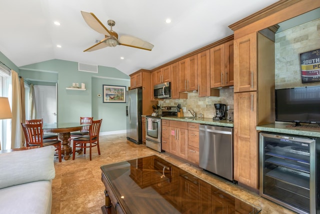 kitchen with lofted ceiling, sink, stainless steel appliances, wine cooler, and decorative backsplash