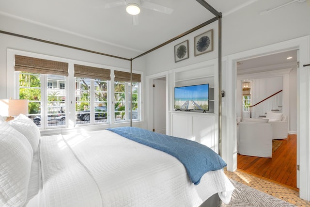 bedroom with hardwood / wood-style flooring, crown molding, and ceiling fan