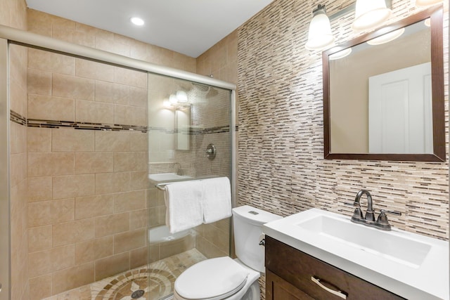 bathroom with tasteful backsplash, vanity, an enclosed shower, and toilet