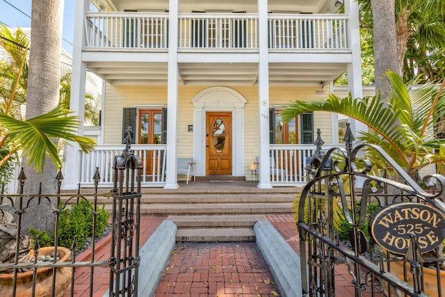 property entrance featuring a balcony and covered porch