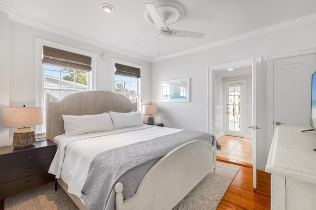 bedroom featuring multiple windows, ornamental molding, and light hardwood / wood-style floors