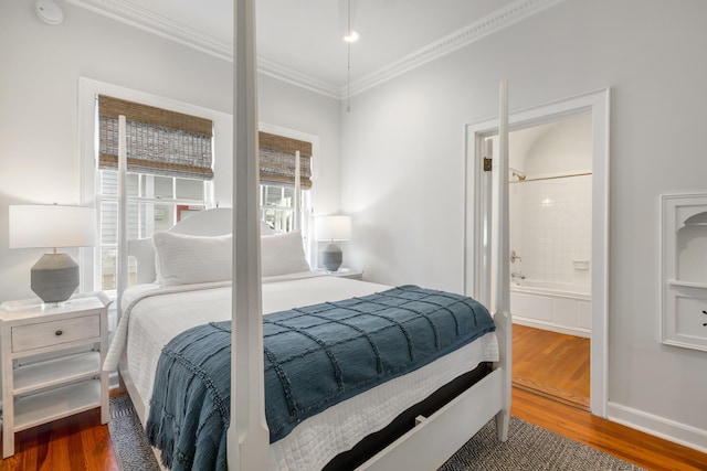 bedroom featuring hardwood / wood-style flooring, ornamental molding, and ensuite bath