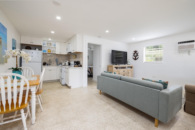 living room featuring sink and an AC wall unit