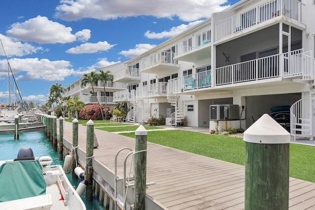 view of dock featuring a lawn, a water view, and central AC