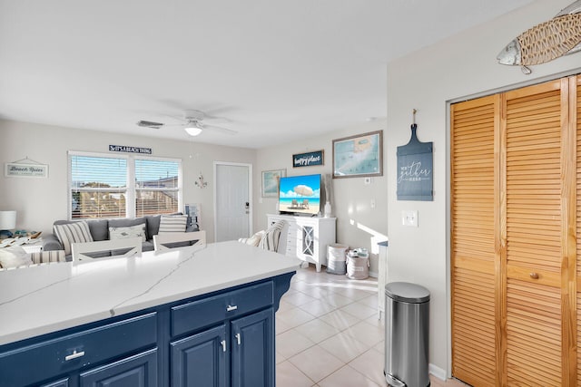 kitchen with blue cabinetry, ceiling fan, and light tile patterned floors