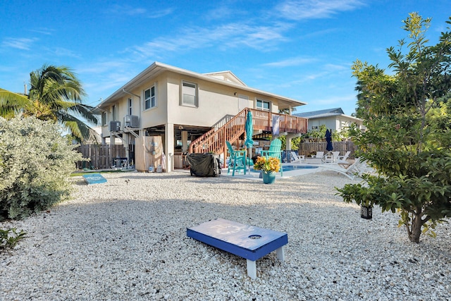 rear view of house with a wooden deck and a patio area