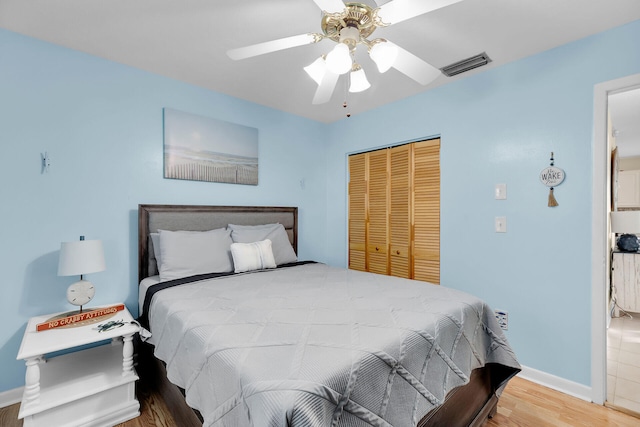 bedroom with hardwood / wood-style flooring, ceiling fan, and a closet