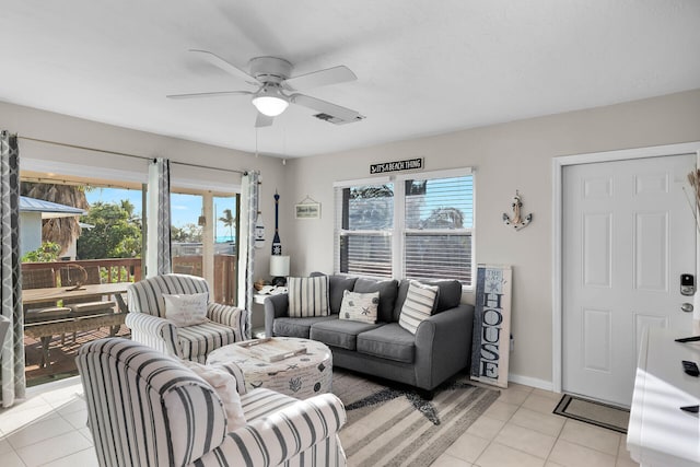 living room featuring light tile patterned flooring, ceiling fan, and a wealth of natural light