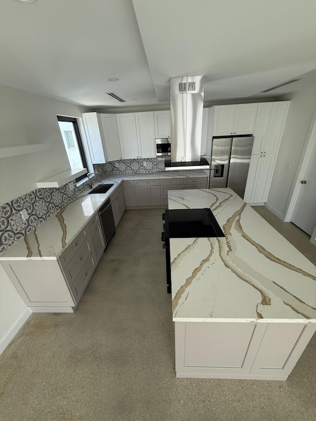 kitchen with white cabinetry, appliances with stainless steel finishes, light stone counters, and island range hood