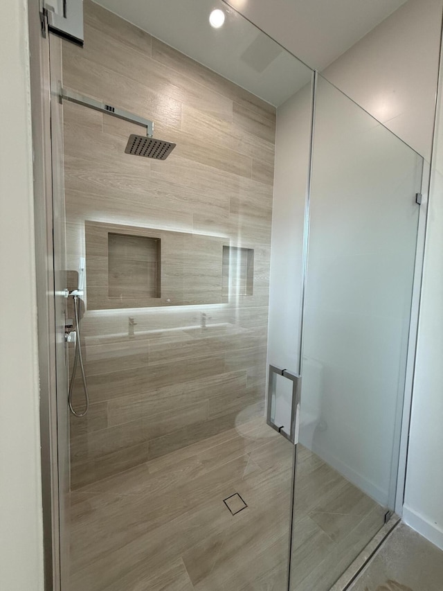 bathroom with a shower with door