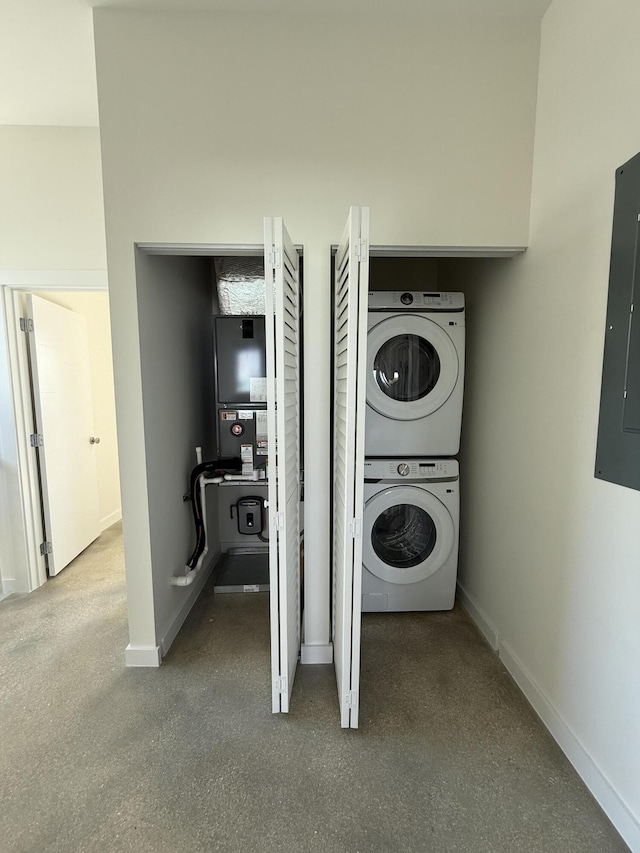 clothes washing area with stacked washer / drying machine and electric panel