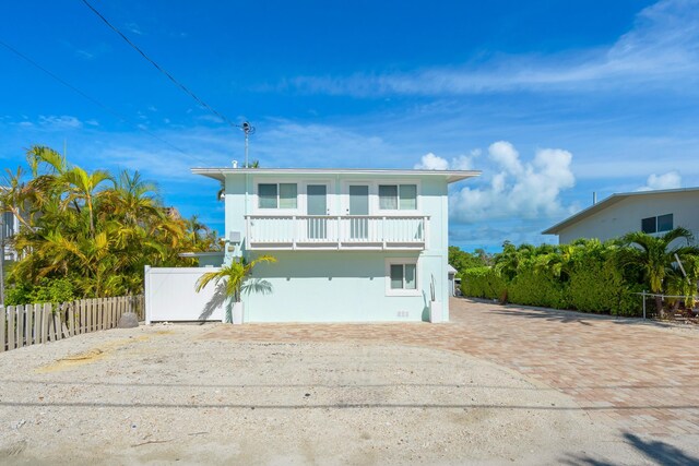 raised beach house featuring a balcony