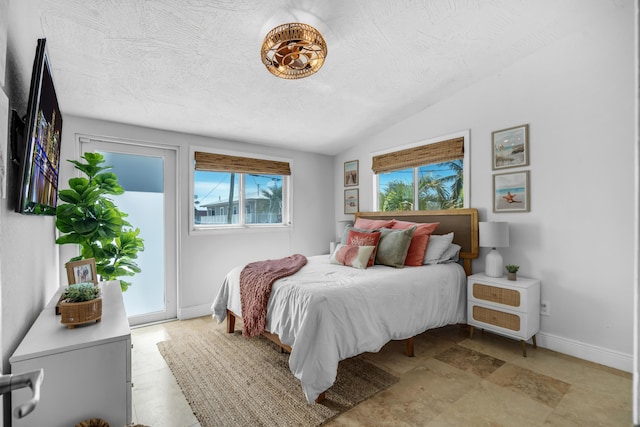 bedroom with lofted ceiling, a textured ceiling, and access to outside