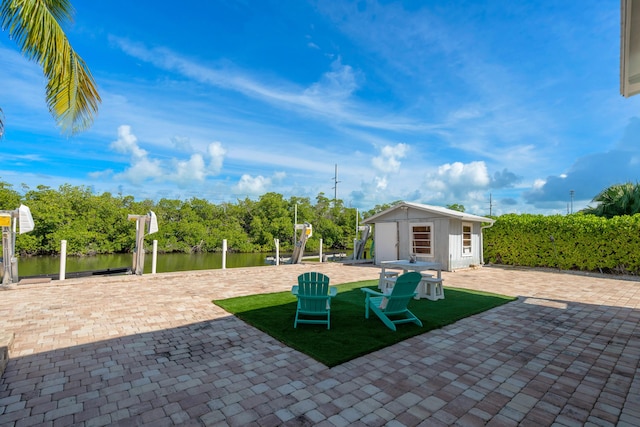 view of patio with a water view and an outdoor structure