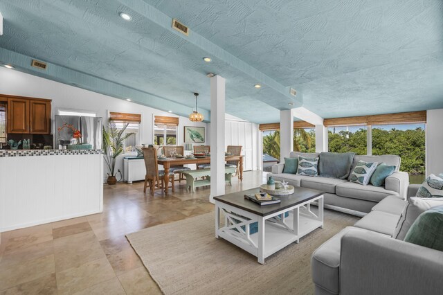 living room featuring vaulted ceiling, a wealth of natural light, and a textured ceiling