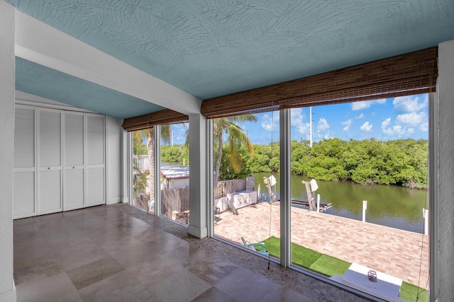 unfurnished sunroom with a water view