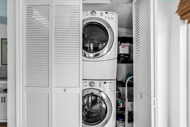 washroom featuring stacked washing maching and dryer