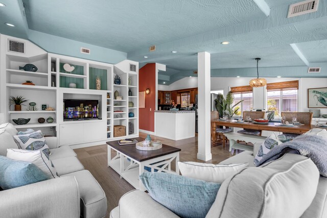 living room with vaulted ceiling, decorative columns, dark hardwood / wood-style floors, and a textured ceiling